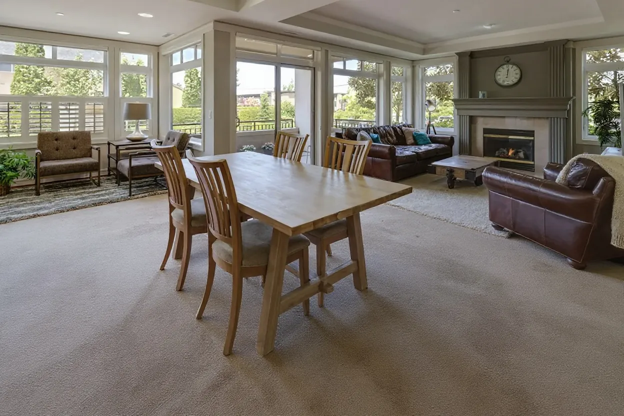 Illustration of the room before: worn beige wall-to-wall carpet under the same table and chairs