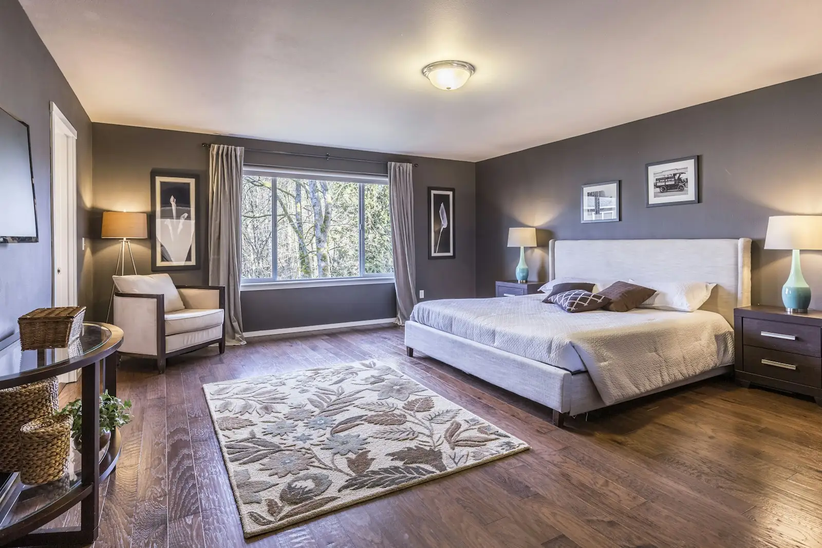 Bedroom with smooth painted walls, white trim and hardwood floors