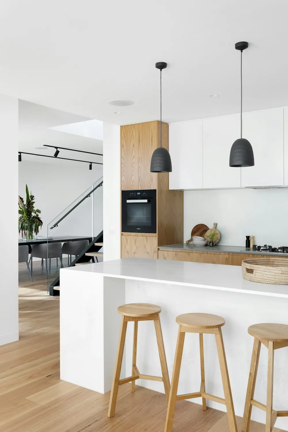 Tall view of a renovated kitchen with a white island and wood floor