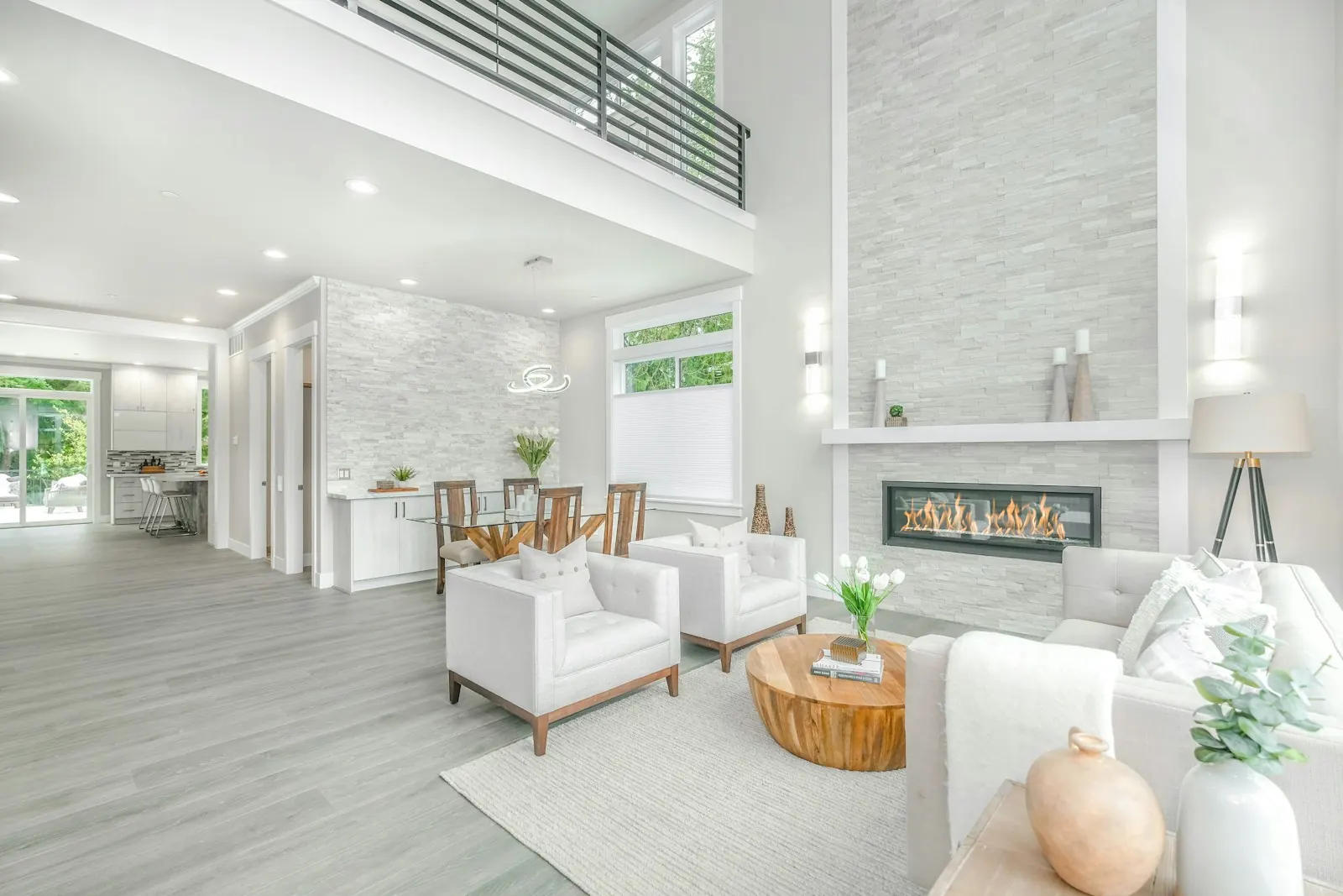 Bright living room with a tall stone fireplace and new flooring