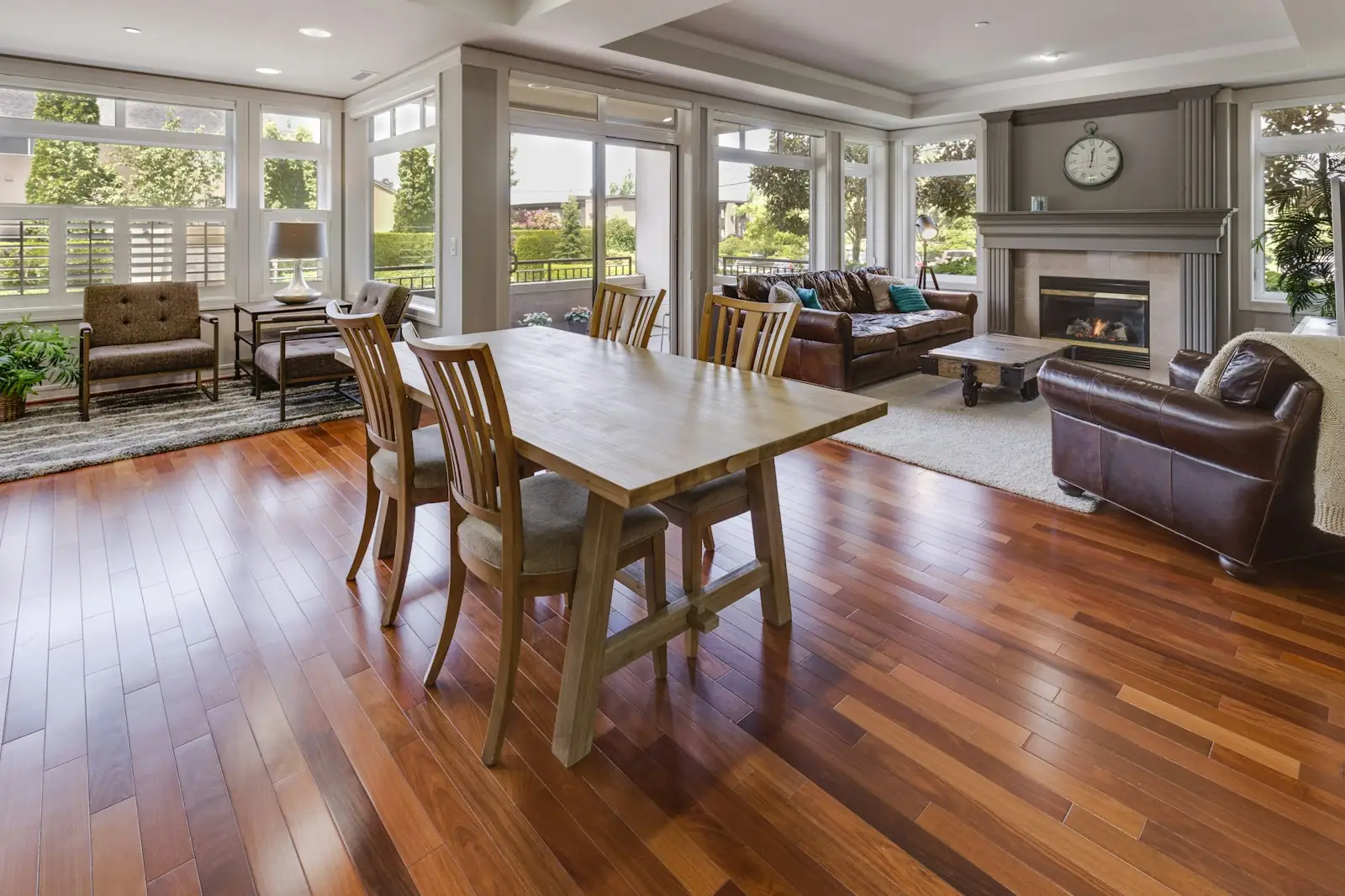 The same living and dining room after: wide plank hardwood running through both rooms