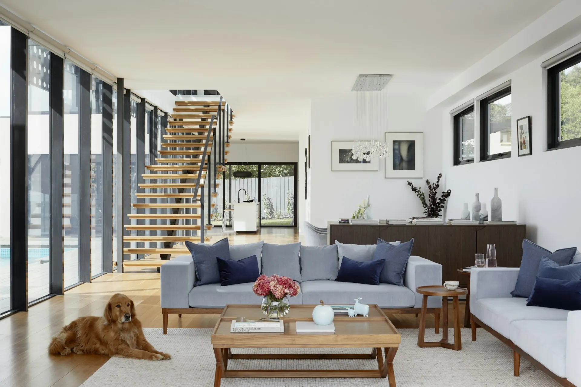The same open room after: smooth white ceiling and walls behind the stairs and sofas